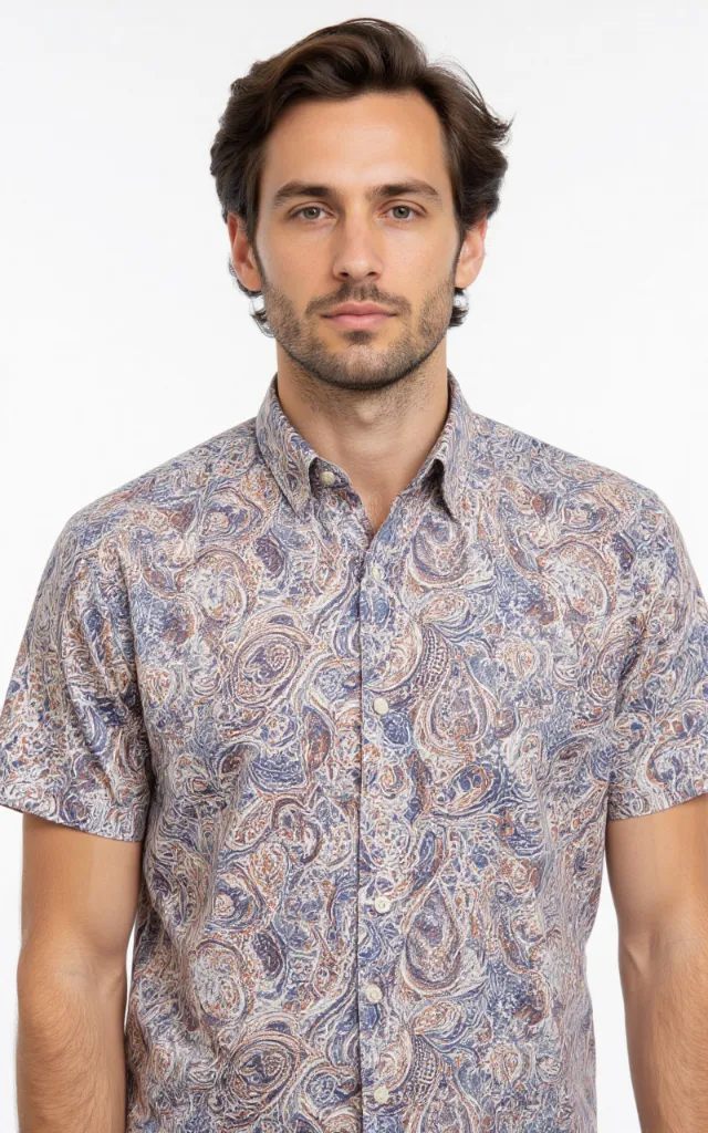 A French model wearing a Paisley pattern   printed shirt, against a white background, in a front   facing bust portrait